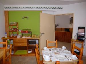 een eetkamer met een tafel en een groene muur bij Pension El Ciervo in Lloret de Mar