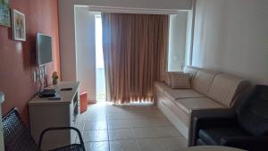 uma sala de estar com um sofá e uma janela em Águas da Serra Apart Hotel em Rio Quente