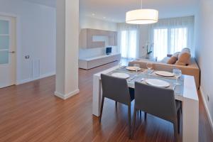 a dining room and living room with a table and chairs at Apartamentos Norte 14 in Salou