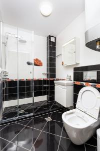 ein schwarz-weißes Bad mit einem WC und einer Dusche in der Unterkunft Beautiful 1BD Apartment with a Parking Spot in Plowdiw