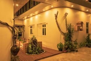 einen Innenhof mit Bäumen und Pflanzen in einem Gebäude in der Unterkunft Nala Island Village in Maafushi