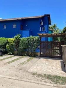 a blue house with a gate in front of it at Mar e Lua Flats - Maresias in Maresias
