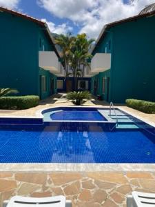 a swimming pool in front of a building at Mar e Lua Flats - Maresias in Maresias