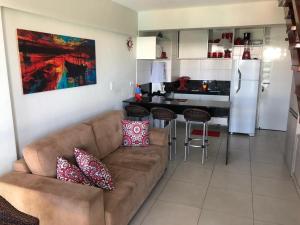 a living room with a couch and a kitchen at Ancorar Flat Porto de Galinhas-Flat 3311-3314 in Porto De Galinhas