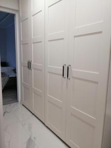 Cette chambre comprend un placard blanc avec des portes blanches. dans l'établissement Apartament Classic Południe, à Włocławek