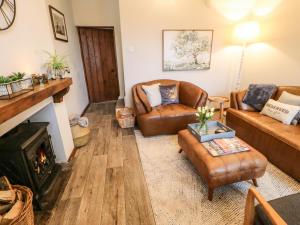 sala de estar con muebles de cuero y chimenea en Magnolia Cottage en Richmond