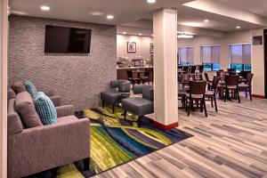 a waiting room with tables and chairs and a tv at Best Western St. Clairsville Inn & Suites in Saint Clairsville