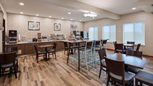 a restaurant with tables and chairs and a bar at Best Western St. Clairsville Inn & Suites in Saint Clairsville