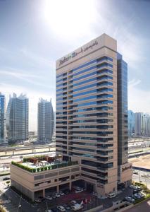 a large building with a large clock on it at Radisson Blu Residence, Dubai Marina in Dubai