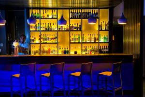 a man sitting at a bar with a drink at Park Inn by Radisson Cape Town Foreshore in Cape Town