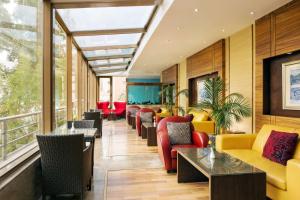 a lobby with yellow and red chairs and tables at Park Inn by Radisson Al Khobar in Al Khobar