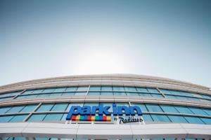 a building with a sign on the side of it at Park Inn by Radisson Dubai Motor City in Dubai