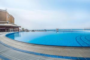 a large blue swimming pool next to a building at Radisson Blu Hotel, Kuwait in Kuwait