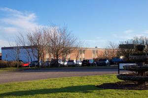 un edificio con coches estacionados en un estacionamiento en Aberdeen Airport Dyce Hotel, Sure Hotel Collection by BW, en Dyce