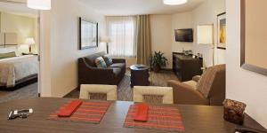 Habitación de hotel con cama y sala de estar. en Sonesta Simply Suites Dallas Richardson, en Dallas