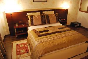 a bedroom with a large bed with a wooden headboard at Hotel Panorama Sarande in Sarandë