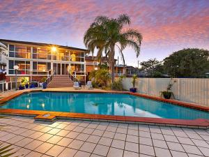 a swimming pool in front of a house at Toukley Waterfront House in Toukley