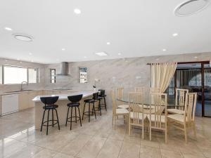 a kitchen with a glass table and chairs and a counter at Toukley Waterfront House in Toukley