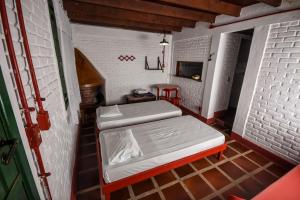 a small room with two beds and a table at Hotel Fazenda Bavaria in São Lourenço