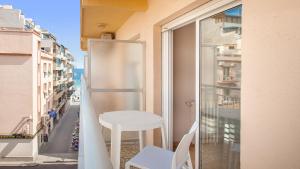 a white stool sitting on a balcony with a window at Hotel RH Sol in Benidorm