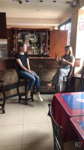 Dos mujeres sentadas en sillas en un restaurante en Hotel Quezada Hermanos, en Santo Domingo de los Colorados