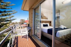 balcone con letto e finestra di Caribbean Motel a Coffs Harbour