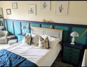 a bedroom with a blue and white bed with pillows at The Buck Inn, Malham in Malham