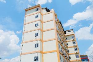 un edificio alto contra un cielo azul con nubes en Hotel Grand Kartika en Samarinda
