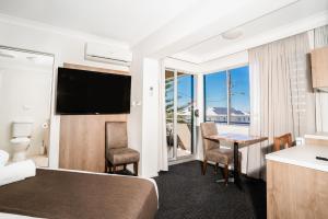 una camera d'albergo con letto e tavolo con sedie di Caribbean Motel a Coffs Harbour