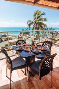 una mesa con comida en el balcón con vistas a la playa en Pousada Boa Vista en Maragogi