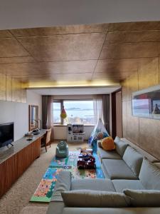 een woonkamer met een bank en een tv bij Shangria Beach Tourist Hotel in Mokpo