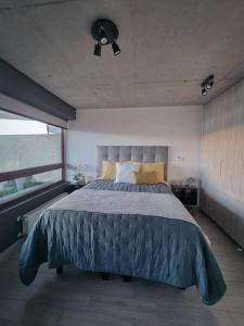 Un dormitorio con una cama grande y una ventana en Nuevo Departamento Vive Barón Valparaíso, en Valparaíso