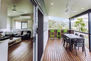 a living room with a balcony with a table and chairs at Woolgoolga Lakeside Holiday Park in Woolgoolga
