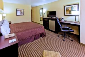 a hotel room with a bed and a desk with a computer at Quality Inn in Council Bluffs +28 photos