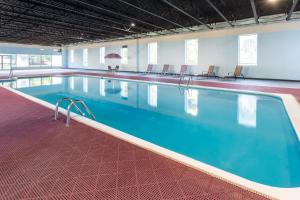 a large swimming pool with blue water in a building at Baymont by Wyndham Queensbury/Lake George in Queensbury