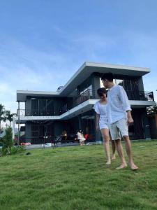 a man and a woman walking in front of a house at Sun Hill Villa Ba Vì - Venuestay in Hanoi