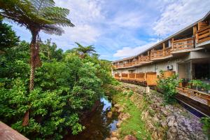a hotel with a river in front of a building at Iriomotejima-Jungle Hotel Painumaya in Iriomote
