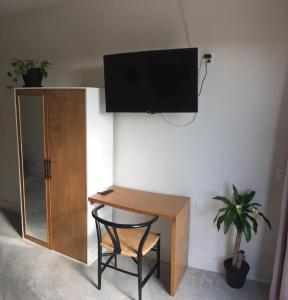 biurko z krzesłem i telewizor na ścianie w obiekcie Black flamingo w mieście Isla Holbox