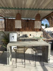una cocina al aire libre con sillas y mesa en Black flamingo en Holbox Island