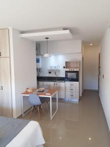 um quarto com uma cozinha, uma mesa e uma cama em Patagonia Apart Dpto 1 em Paraná