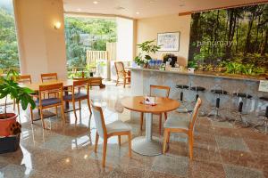 a restaurant with tables and chairs and a counter at Iriomotejima-Jungle Hotel Painumaya in Iriomote