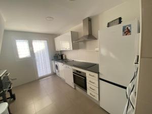 a kitchen with a white refrigerator and a stove at Casa Rural Cascadas del Hueznar in San Nicolás del Puerto