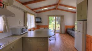 a kitchen with a counter top and a living room at River Bend Caravan Park in Kanyapella