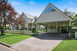 a large white house with a driveway at Creek Cottage Bed and Breakfast Traralgon in Traralgon