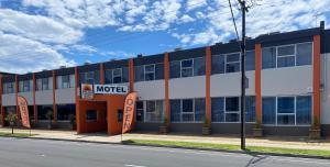 un edificio de motel en la esquina de una calle en Adelaide Airport Motel en Adelaida