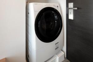 uma máquina de lavar e secar roupa num quarto ao lado de uma porta em Tokyu Stay Shinjuku Eastside em Tóquio