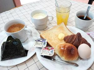 a white plate of breakfast food with eggs bacon and toast at City Inn Nishi Tanabe in Osaka