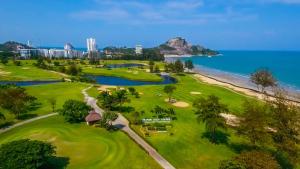 an aerial view of a golf course with the ocean at Seapine Beach Golf and Resort Hua Hin in Hua Hin
