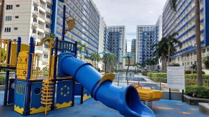 um parque infantil com um escorrega azul numa cidade em MSH property Sea Residences MOA Pasay City by Queennie em Manila