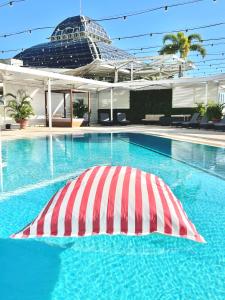 
a swimming pool with a blue umbrella on top of it at Pullman Reef Hotel Casino in Cairns
